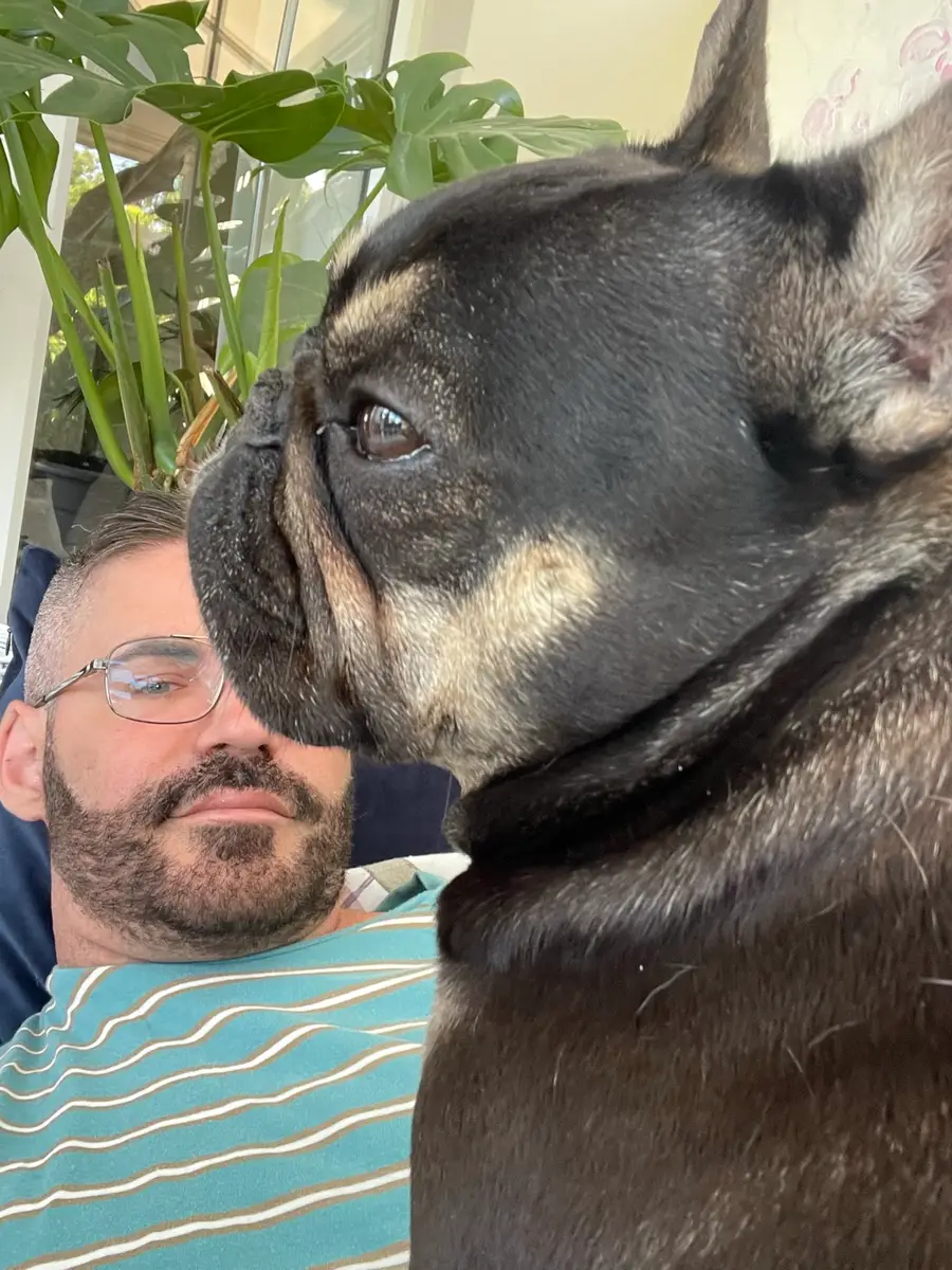 Coco resting her head affectionately against her owner's cheek.