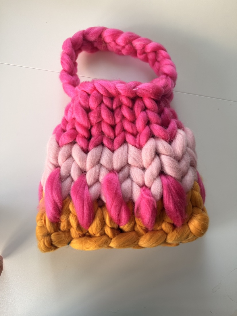A chunky-knit handbag made from leftover Gigante wool in pink, blush and mustard