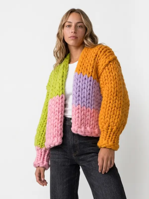 The Technicolor cardigan worn standing, one lime arm and one orange arm.